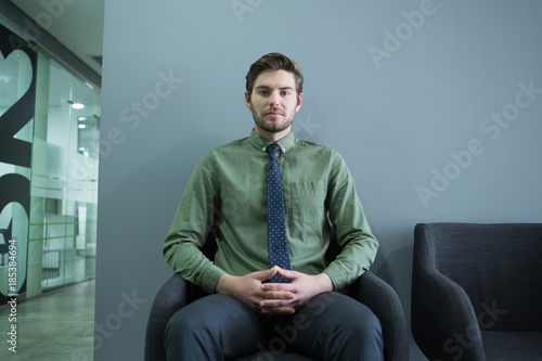 Confident executive sitting on chair in waiting area