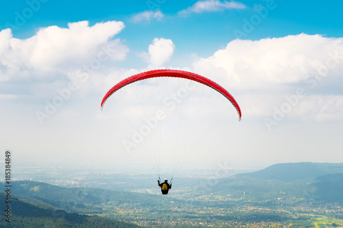 Paraglider flying over the fields on a sunny day. Poland.