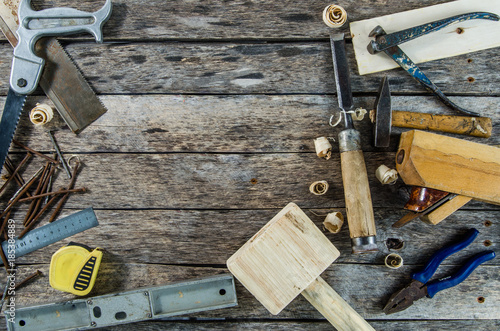 The carpenter tools on wooden bench, plane, chisel,mallet, tape measure, hammer, tongs, pliers, level, nails and a saw