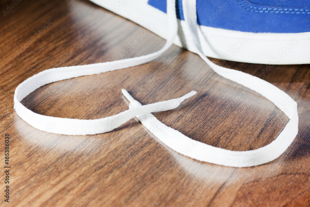 Sign of love, selective focus close blue sports shoes on a wooden floor.