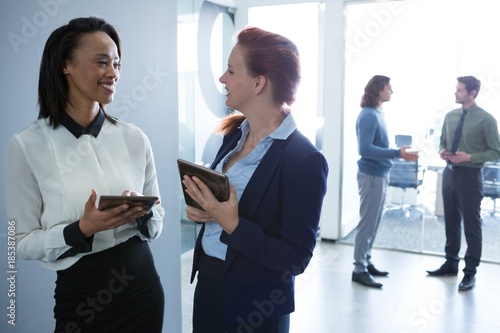 Female executives discussing over digital tablet