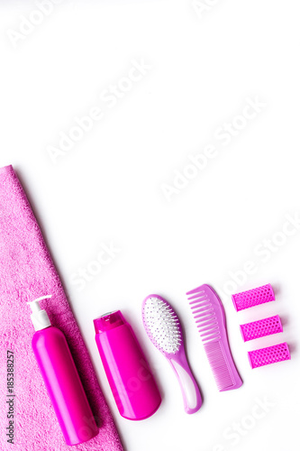 Basic hair care in bathroom. Comb  shampoo  spray  curlers  towel on white background top view copyspace