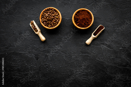 Coffee background. Roasted beans and ground coffee in bowls and scoops on black table top view copyspace