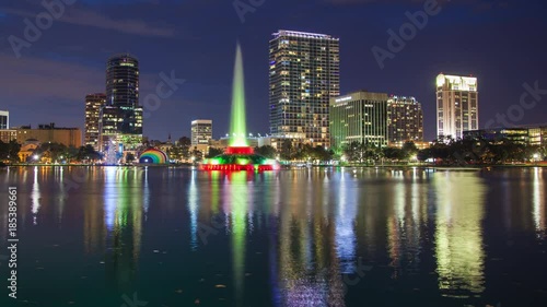 Wallpaper Mural Orlando FL City Skyline Evening Timelapse over Lake Eola Park featuring the Fountain and Building Lights Reflecting onto the Water at Dusk Torontodigital.ca