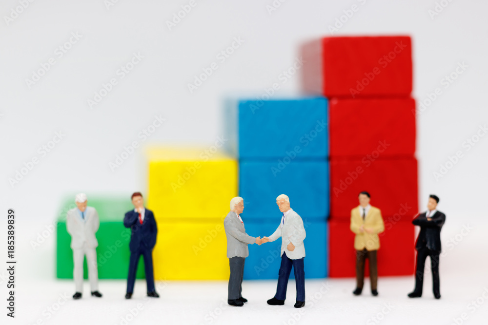 Miniature people handshake with step of Wood block stack. agreement, investment, partnership and business concept Miniature people handshake with step of Wood block stack. agreement, investment, partnership and business concept