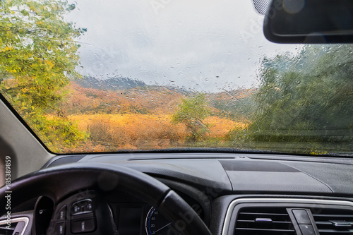 rain drops on the window of the car. autumnal rainy landscape blurred