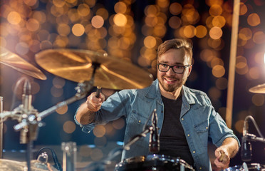 musician or drummer playing drum kit at concert