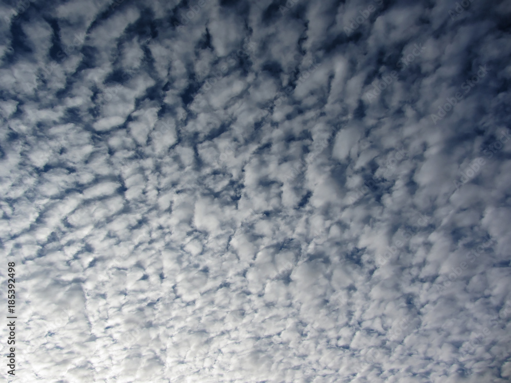 Many soft little clouds against blue sky background