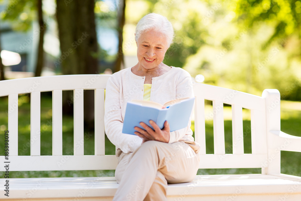 Fototapeta premium happy senior woman reading book at summer park