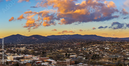 beautiful clouds lit up for sunset over a small mountain town © Brent Hall