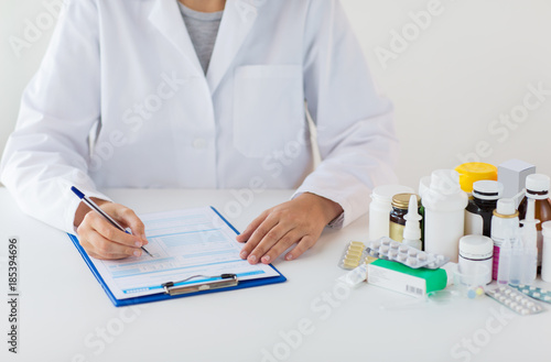 doctor with medicines and clipboard at hospital