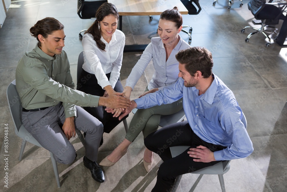 Group of executives stacking hands over each other Group of executives stacking hands over each other