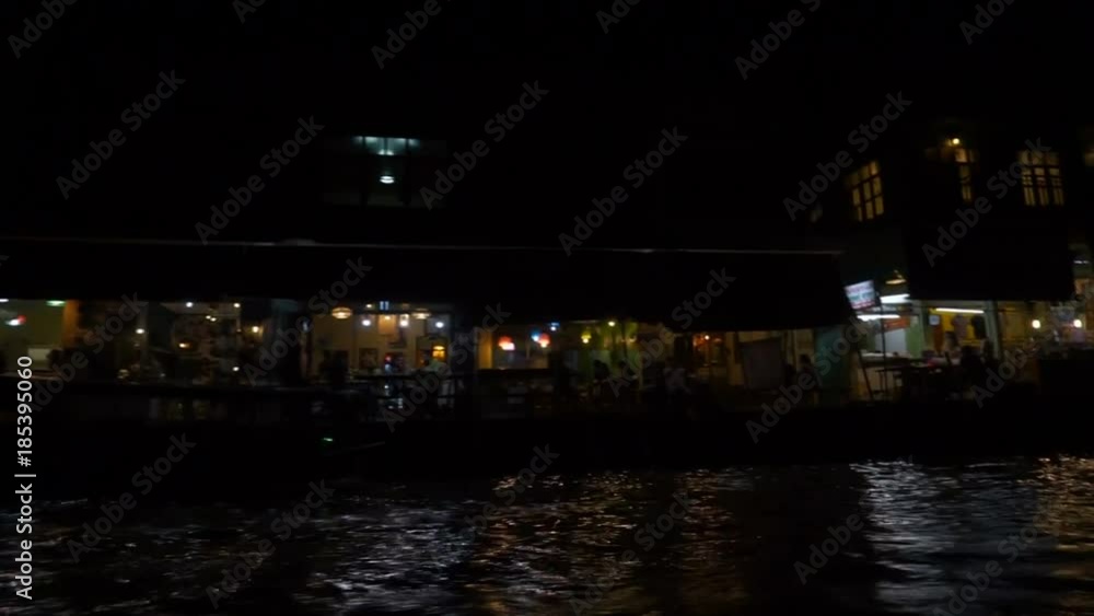 Amphawa,Thailand.December 2,2017. POV from thai local passenger boat for tourist with driver is sailing pass through house at mae klong river at night. Amphawa,Thailand.December 2,2017. POV from thai local passenger boat for tourist with driver is sailing pass through house at mae klong river at night.