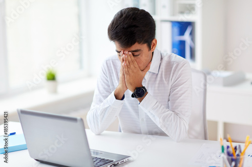 stressed businessman with laptop at office