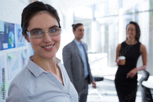 Beautiful female executive wearing spectacles looking at camera