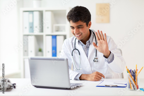 doctor having video conference on laptop at clinic