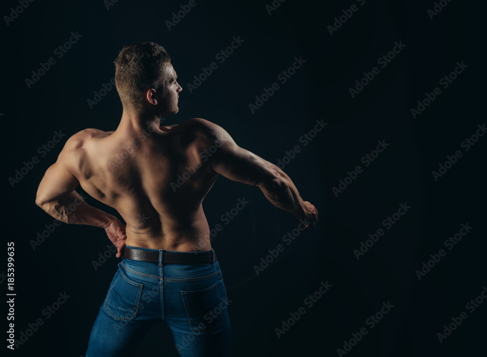 Fototapeta premium Athlete man with bare torso in blue jeans, back view