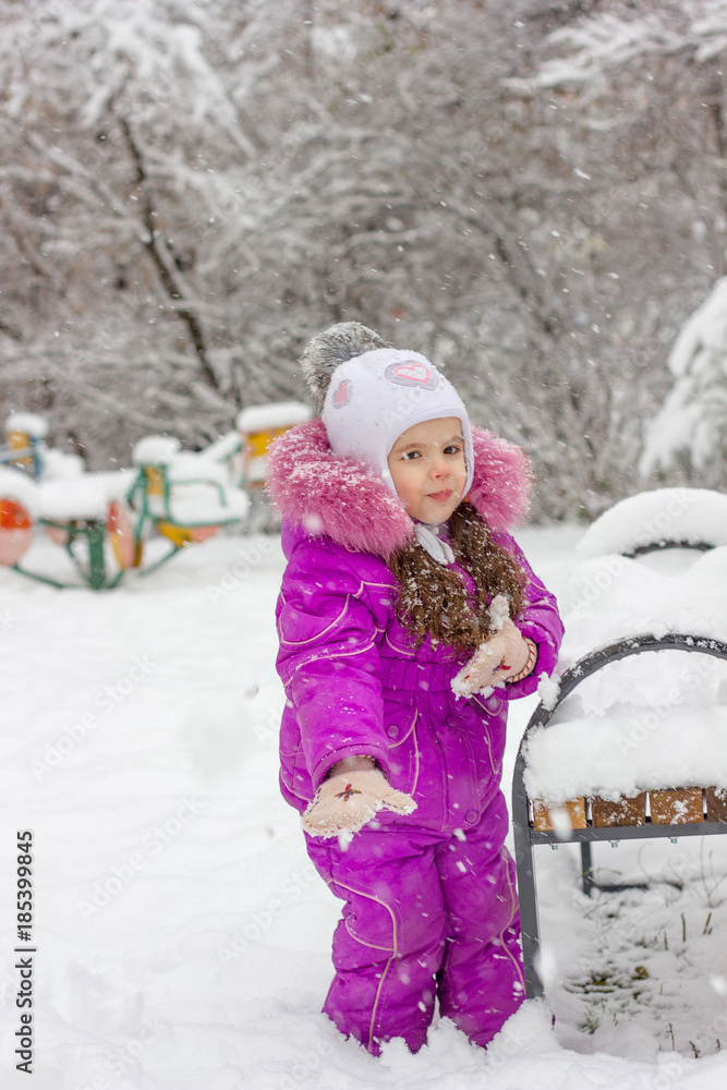 Little girl plays snowballs at winter day outdoors. Little girl plays snowballs at winter day outdoors.