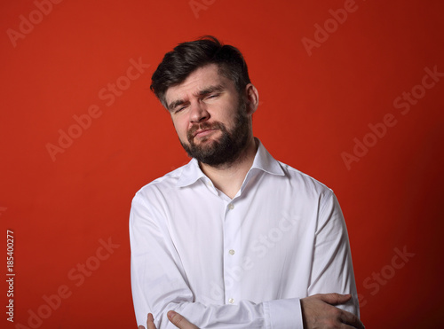 Unhappy tired thinking bearded business man in white shirt on red background. Portrait of stress © nastia1983