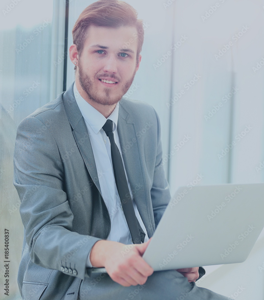 Handsome businessman working with laptop in office Handsome businessman working with laptop in office