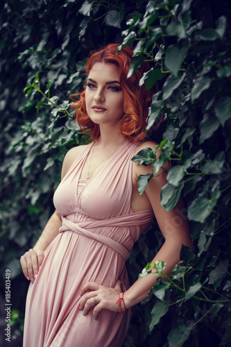 Lovely young woman in a pink dress, waiting for a date.