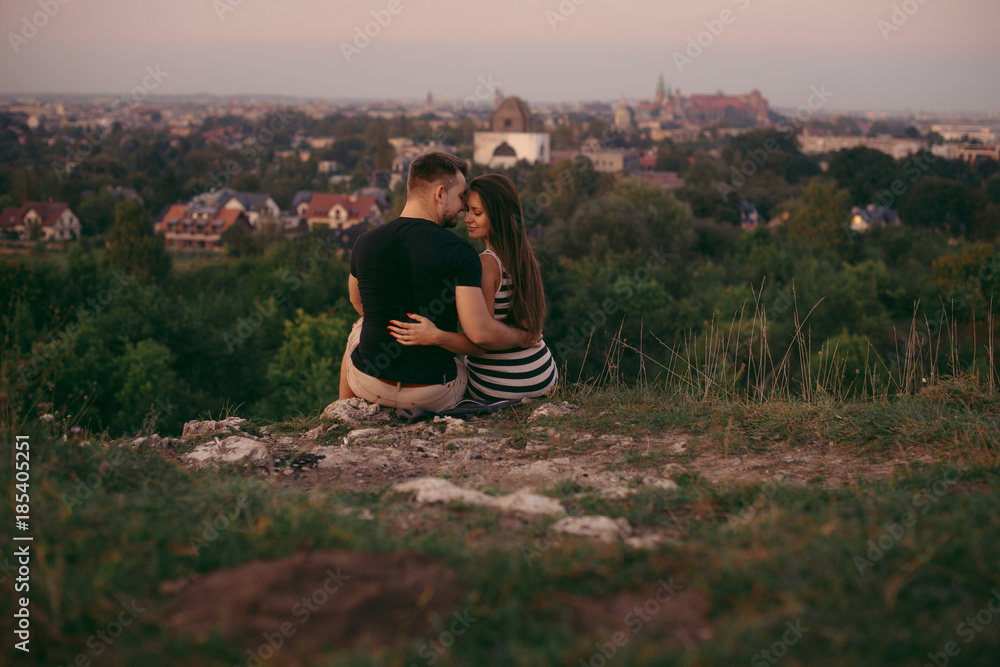 Young couple in love outdoor. Beautiful nature and warm sunset 