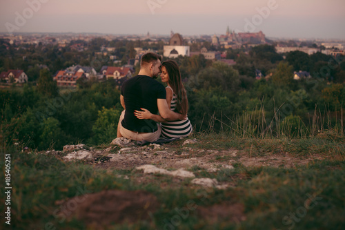 Young couple in love outdoor. Beautiful nature and warm sunset 