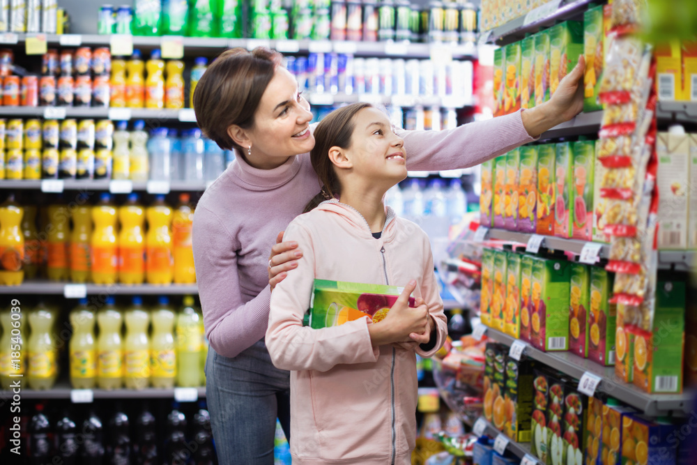 Female shopper with teenage daughter searching for beverages