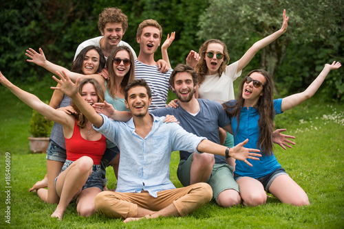Group of young people sitting in the grass, posing for a photo