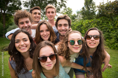 Group of young people standing in the grass, posing for a photo