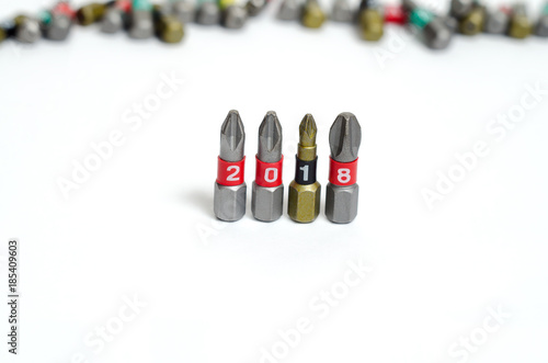 Obraz na płótnie Set of heads for screwdriver (bits) in New year order 2018. Tools collection close up, blurred white background. w salonie