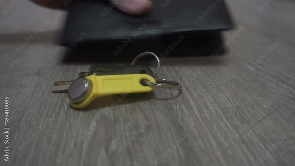 the hand of the young man takes the keys and wallet from the table,the concept of leaving the house. the hand of the young man takes the keys and wallet from the table,the concept of leaving the house.