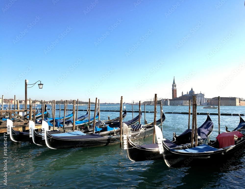VENICE, ITALY - DECEMBER 20, 2017 : gondolas parked in front of san Marco plaza harbor in Venice city center.