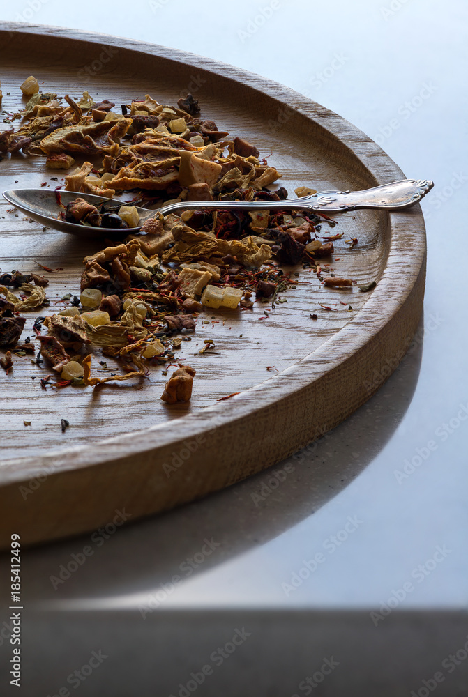 Dried fruits and herbs on the wooden plate with silver spoon. Dried fruits and herbs on the wooden plate with silver spoon.