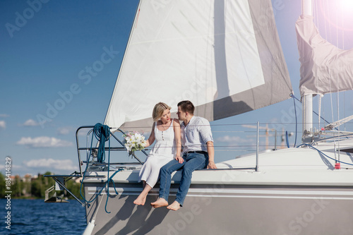 A couple in love on a yacht. blonde girl and brunette guy for a walk on the sea © velimir
