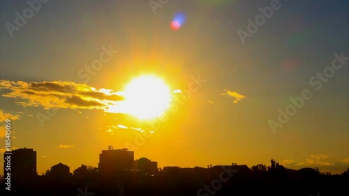 Wallpaper Mural Lovely Time Lapse of sunset, with big golden sun, with golden clouds, with lense flares, against the background of the city silhouette. The camera approach. Torontodigital.ca