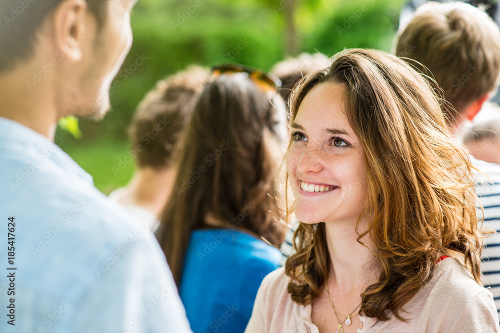 On a college campus students meet, focus on a young woman