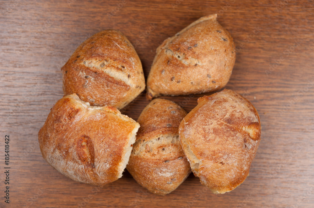 fresh baked bread with cereals on cutting board on wooden table