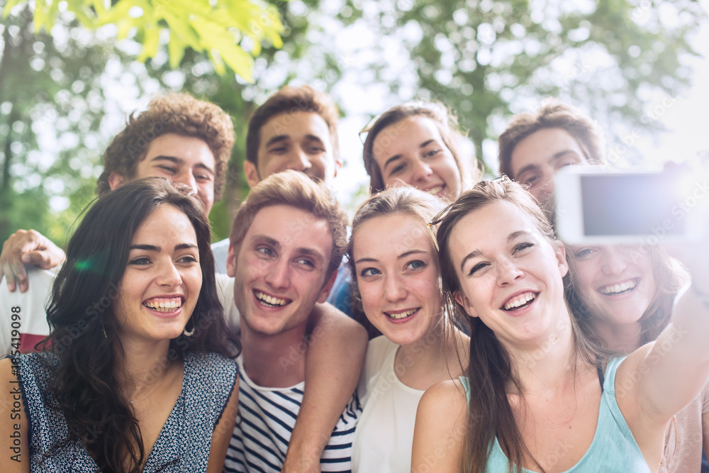 Group of young people taking a selfie outside Group of young people taking a selfie outside