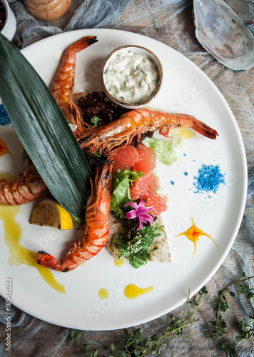 beautiful serving of tiger prawns on the grill with salad and grapefruit