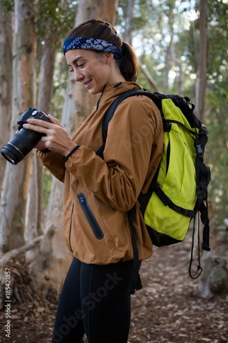 Young woman with backpack standing in the forest