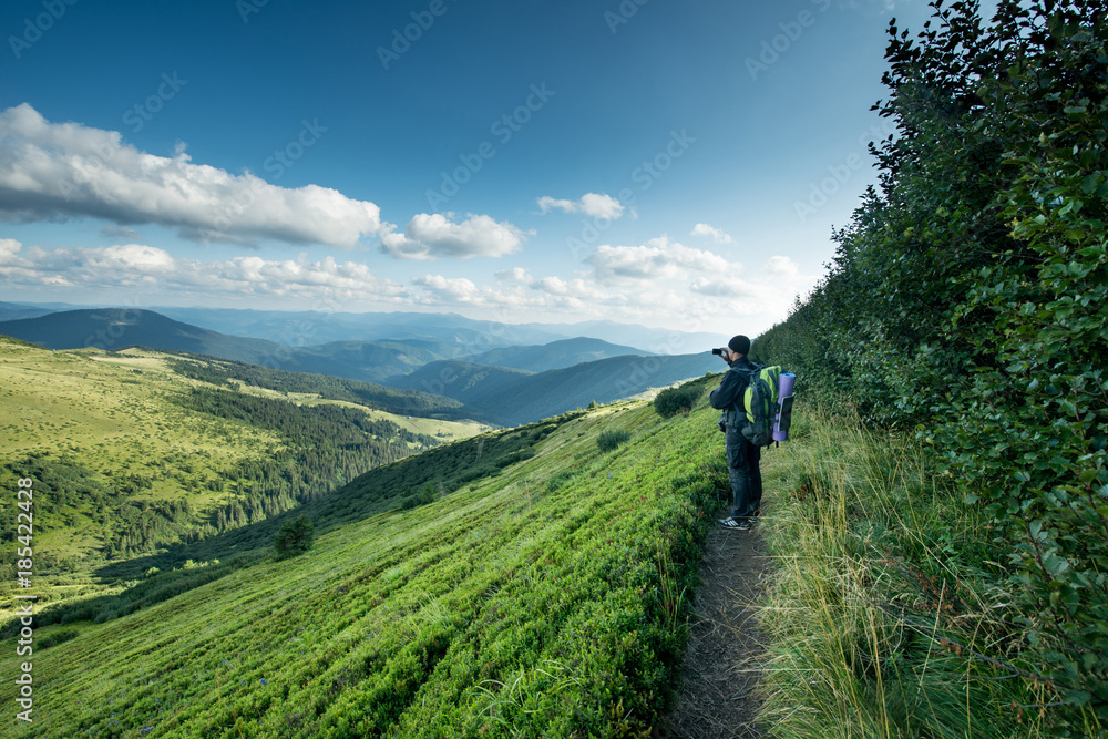Traveler with backpack and smartphone on the mountains