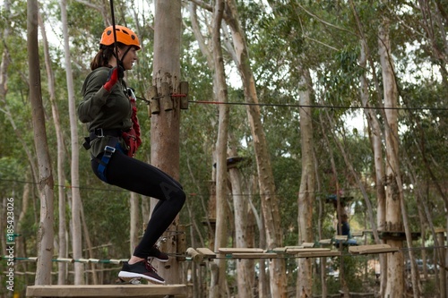 Young woman crossing through a zip line