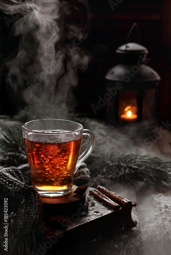 cup of boiling black tea in winter decorations