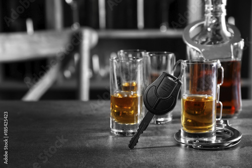 Composition with alcohol, handcuffs and car key in bar. Don't drink and drive concept