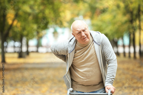 Fototapeta Naklejka Na Ścianę i Meble -  Elderly man with walking frame in autumn park