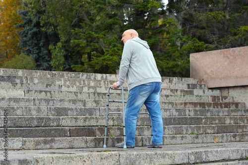 Elderly man with walking fr...