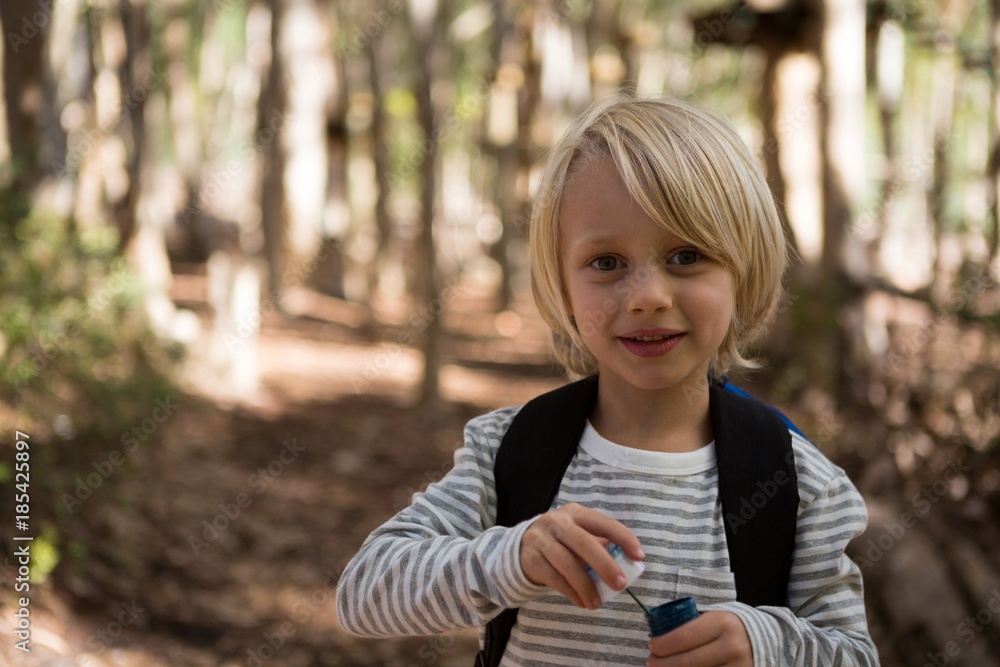 Little girl holding bubble wand in her hand in the forest on a Little girl holding bubble wand in her hand in the forest on a