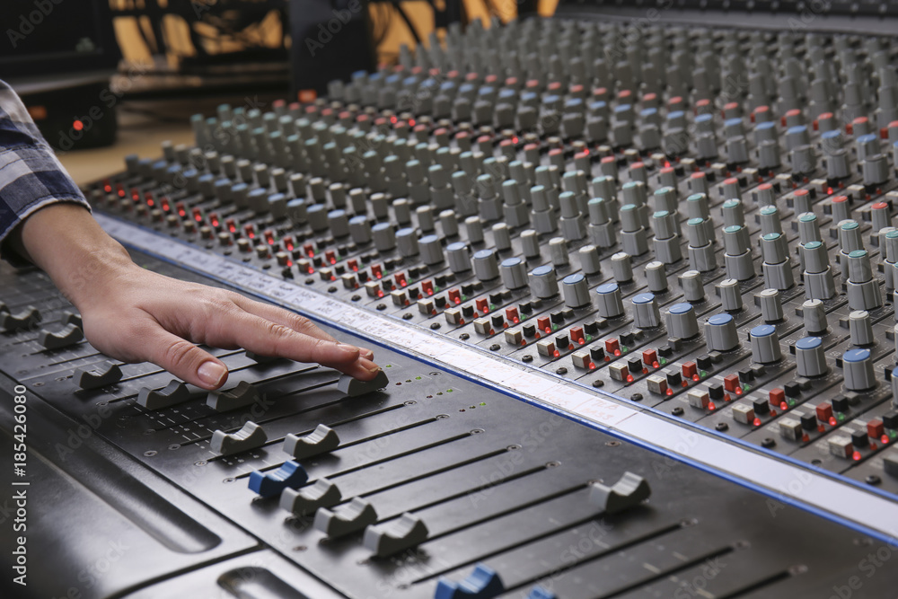 Radio host working with mixer in studio Radio host working with mixer in studio