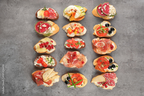 Delicious bruschettas on grey background, top view